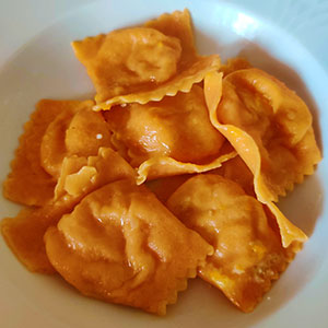 Ravioli rossi con ripieno di patate e pancetta